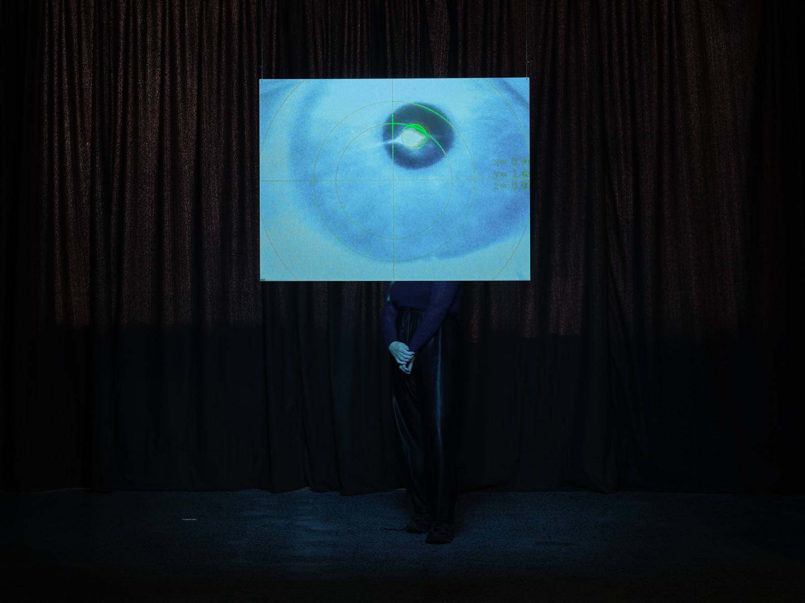 A hanging screen has a close up image of an eye with an overlaid grid.