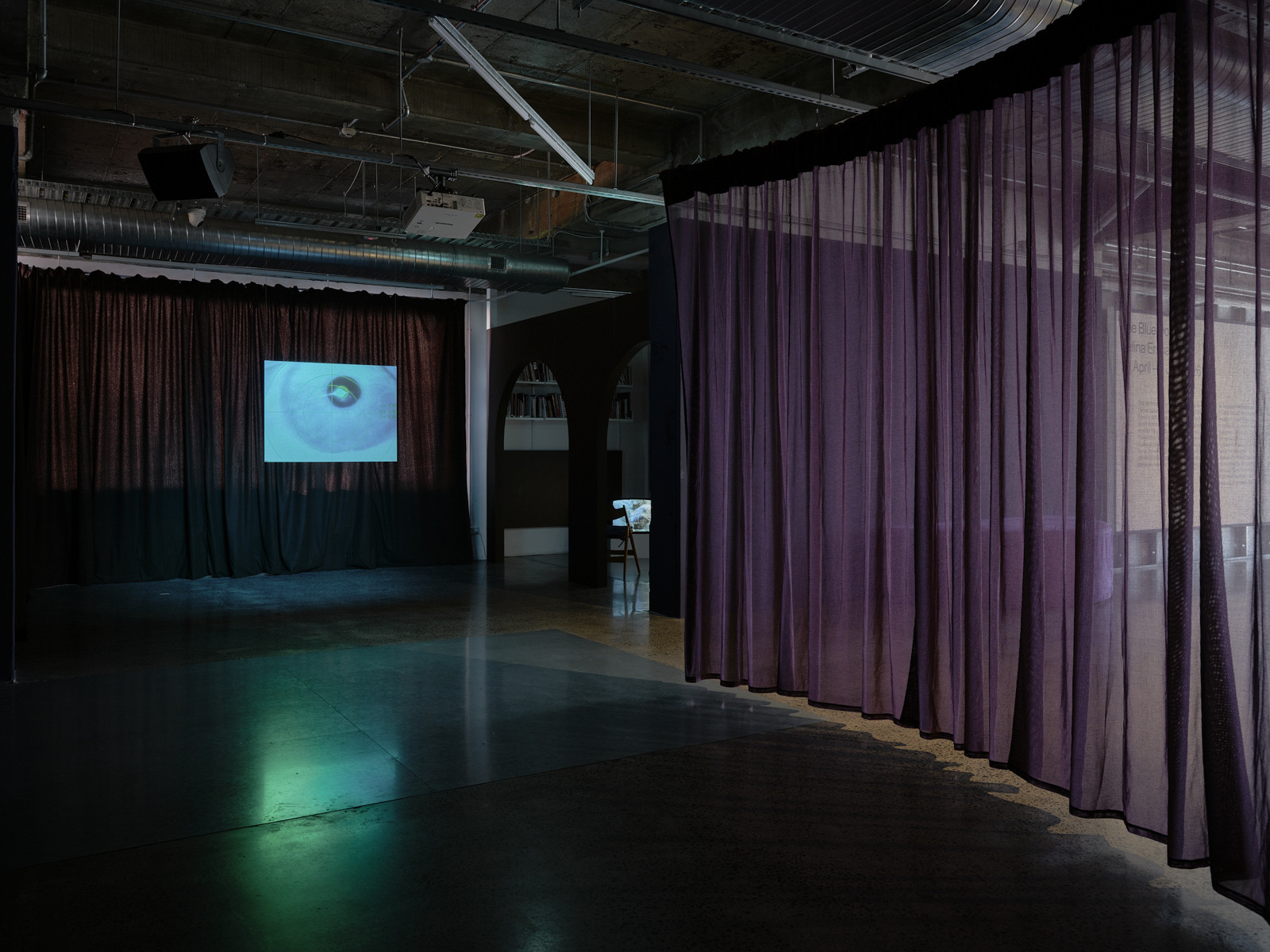 A hanging screen is in the background with a sheer curtain to the right.