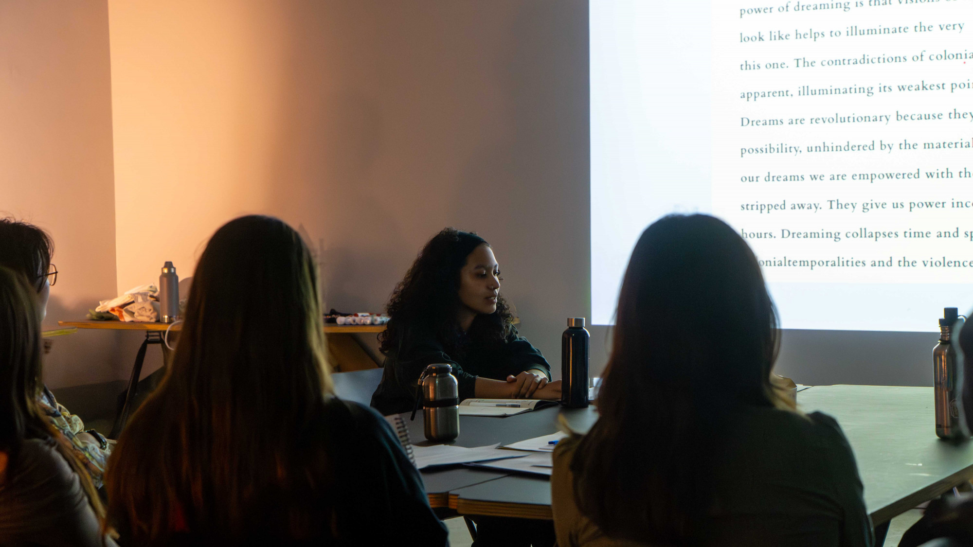 One person sitting in front of a table delivering a presentation